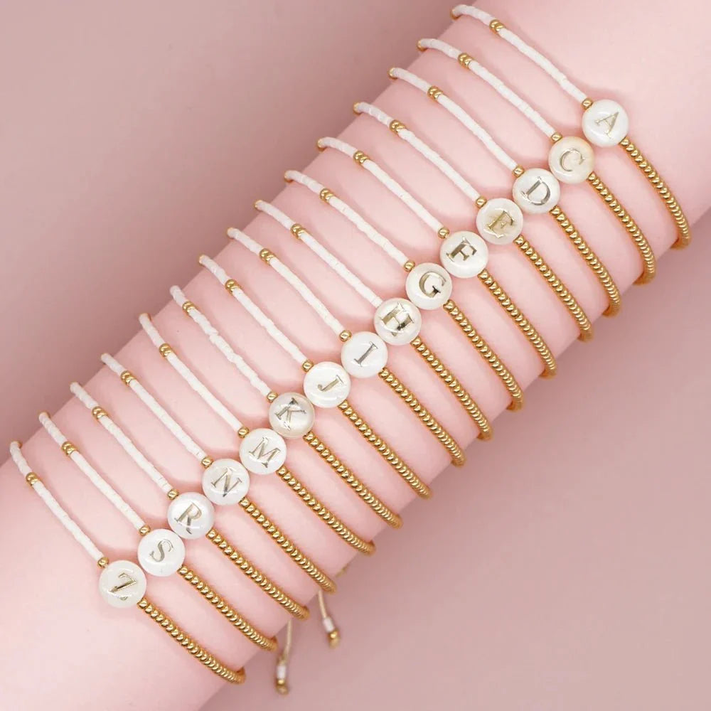 Bracciale boho con perline bianche e oro e iniziale personalizzabile