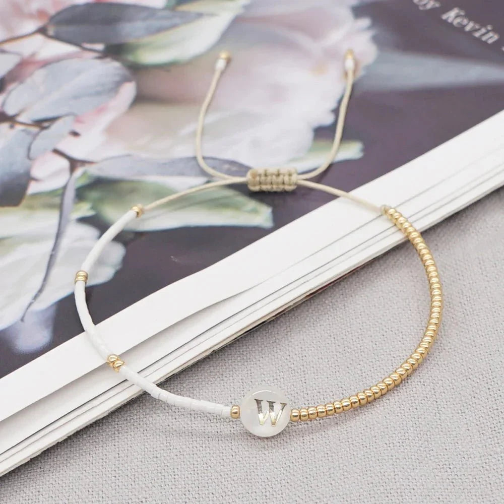 Bracciale boho con perline bianche e oro e iniziale personalizzabile