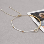Bracciale boho con perline bianche e oro e iniziale personalizzabile