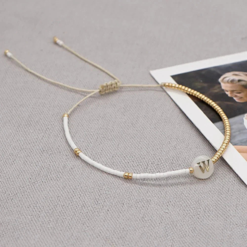 Bracciale boho con perline bianche e oro e iniziale personalizzabile