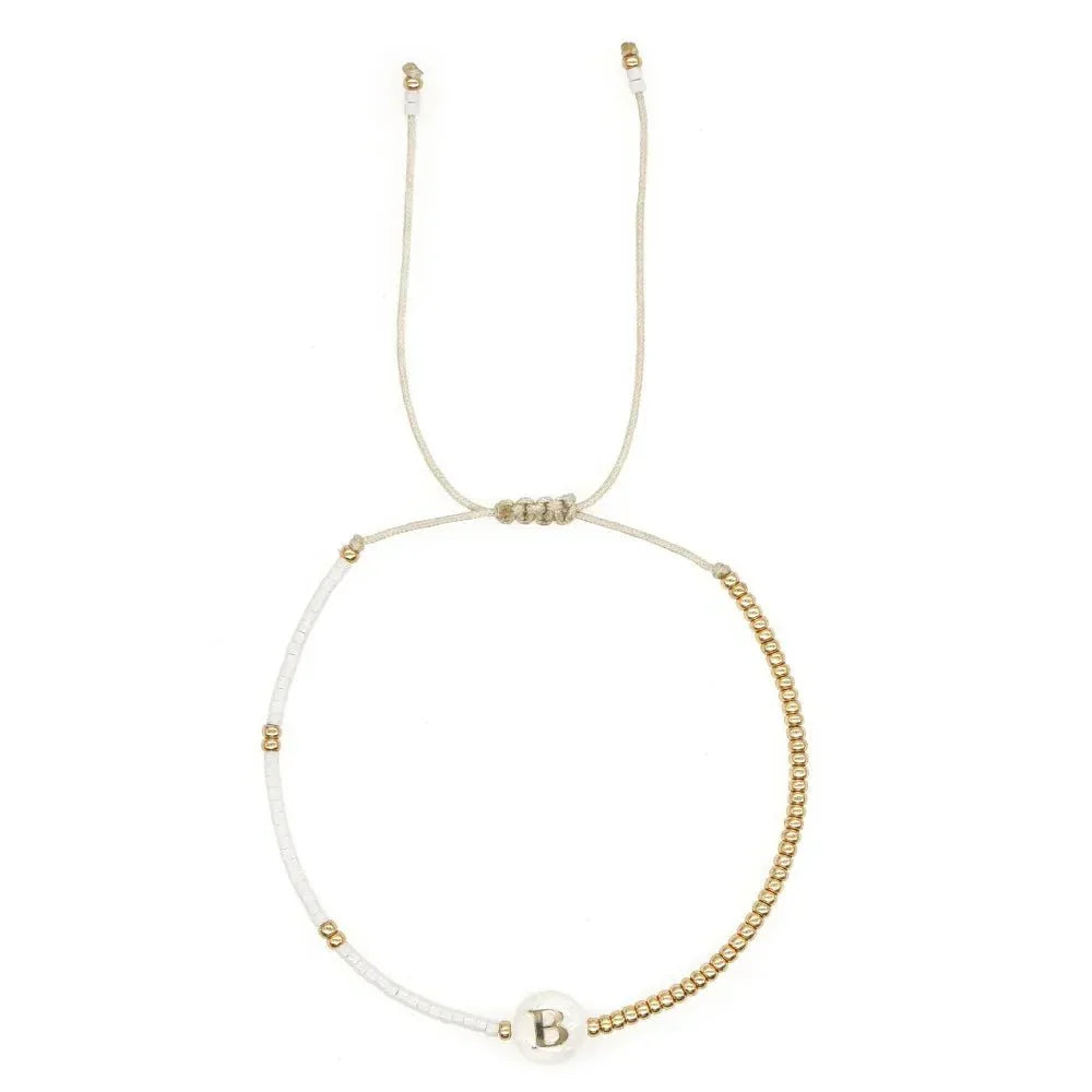 Bracciale boho con perline bianche e oro e iniziale personalizzabile