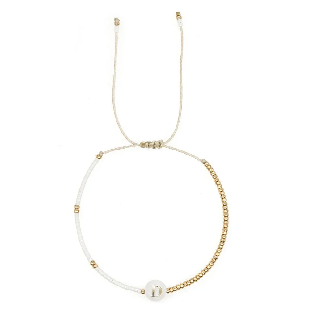 Bracciale boho con perline bianche e oro e iniziale personalizzabile