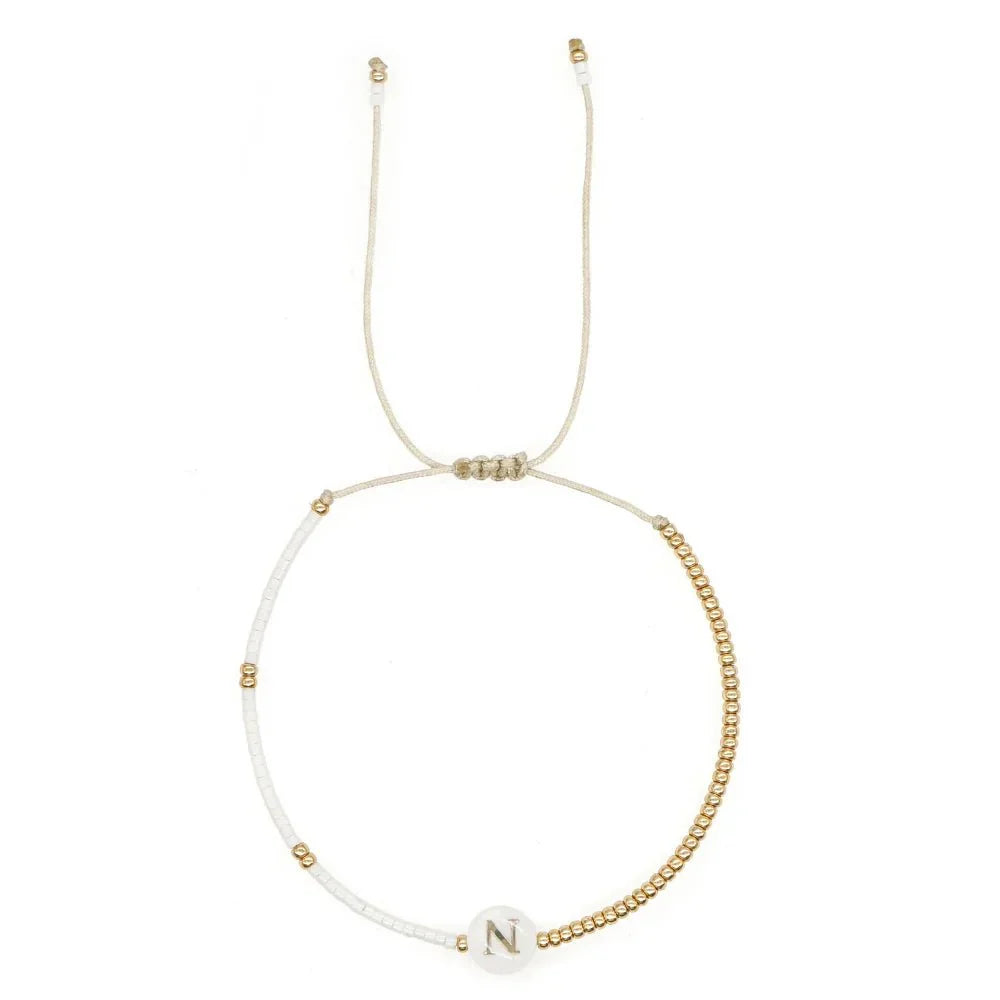 Bracciale boho con perline bianche e oro e iniziale personalizzabile