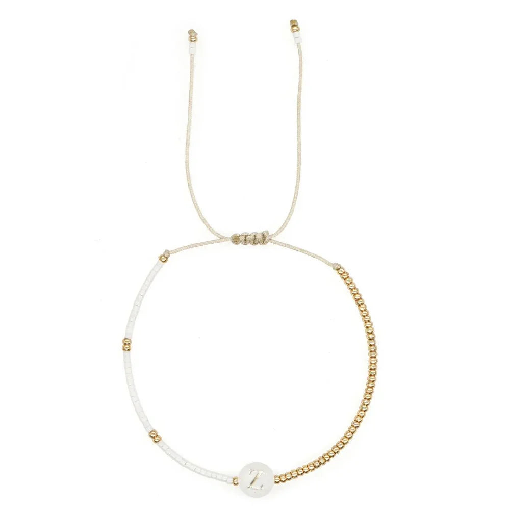 Bracciale boho con perline bianche e oro e iniziale personalizzabile