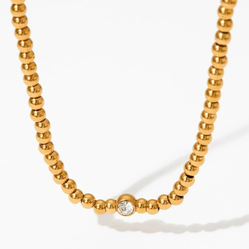 Collana e bracciale con perline e diamante centrale 18k