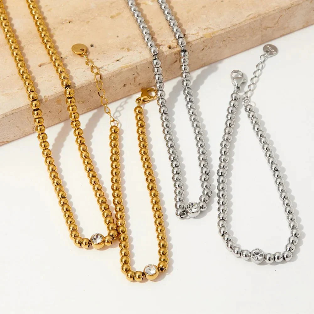 Collana e bracciale con perline e diamante centrale 18k