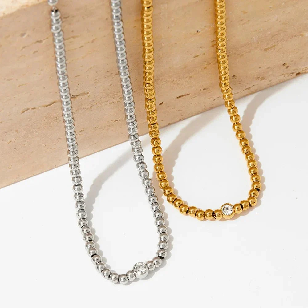 Collana e bracciale con perline e diamante centrale 18k