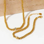 Collana e bracciale con perline e diamante centrale 18k