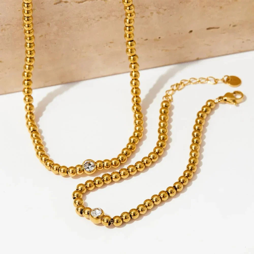 Collana e bracciale con perline e diamante centrale 18k