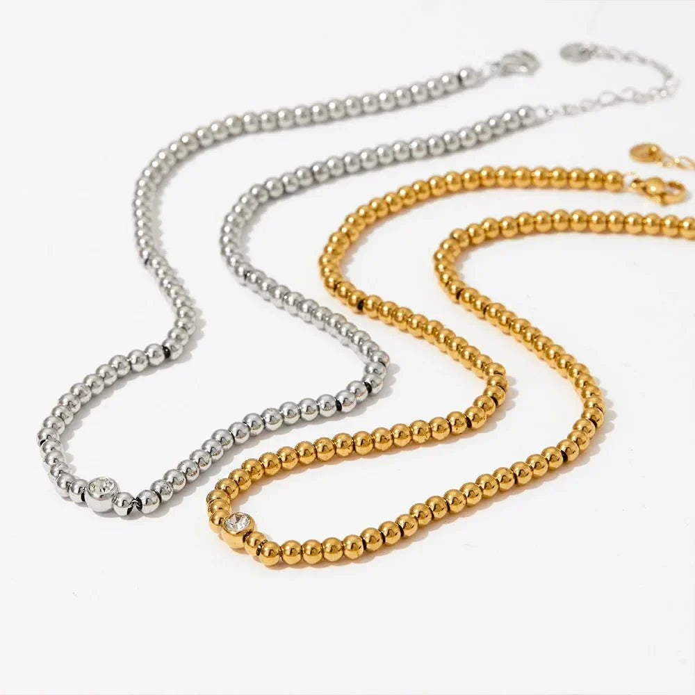 Collana e bracciale con perline e diamante centrale 18k
