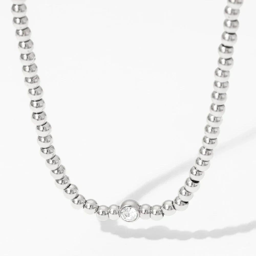 Collana e bracciale con perline e diamante centrale 18k
