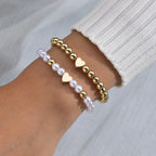 Set 2 bracciali con perline bianche e oro e ciondolo cuore