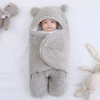Neonato protetto dal freddo nella coperta avvolgente termica con velcro