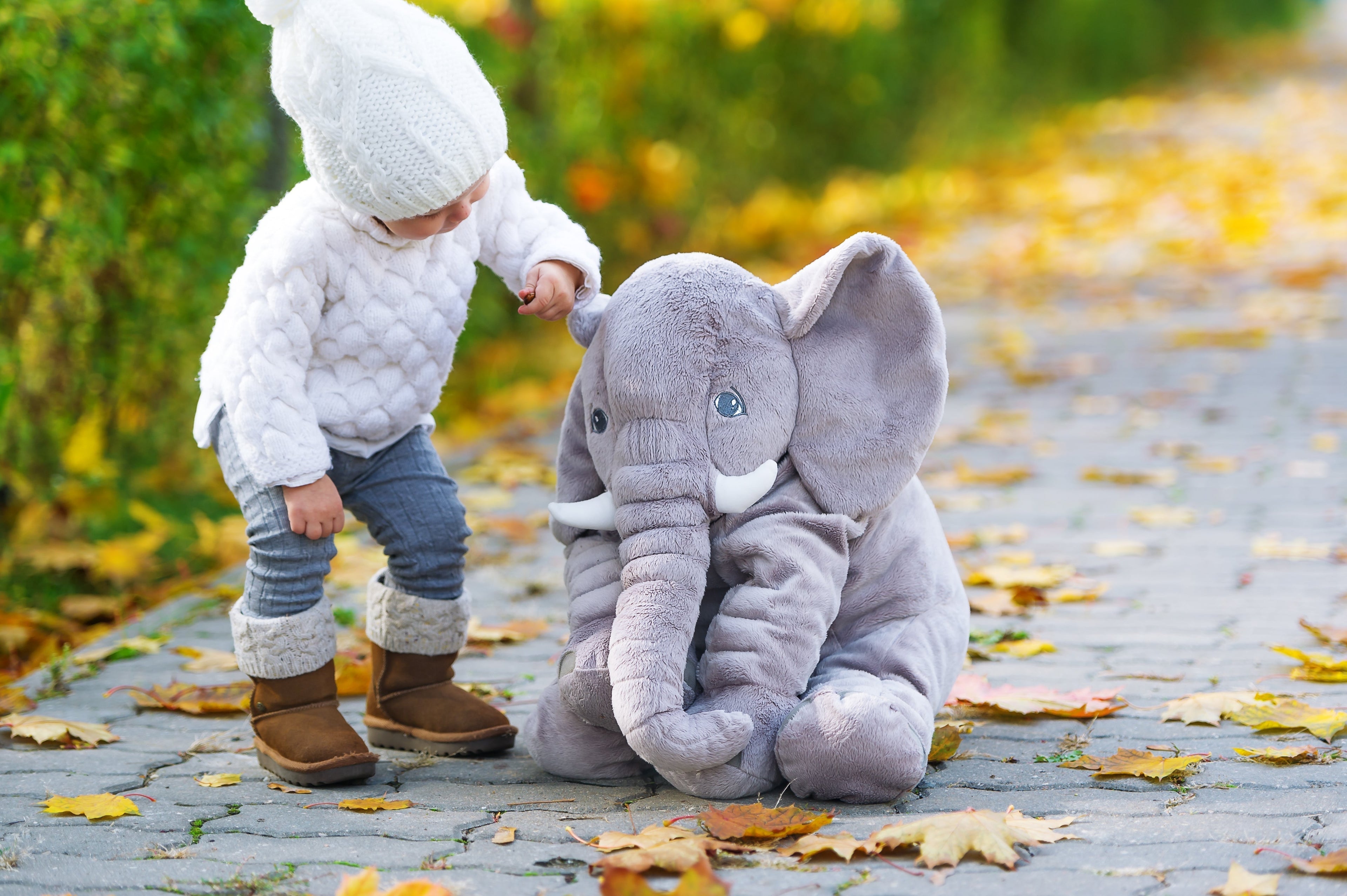 Neonato che riposa con elefante peluche morbido come supporto