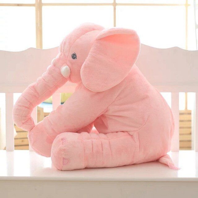Bambino piccolo con elefante peluche gigante durante il gioco