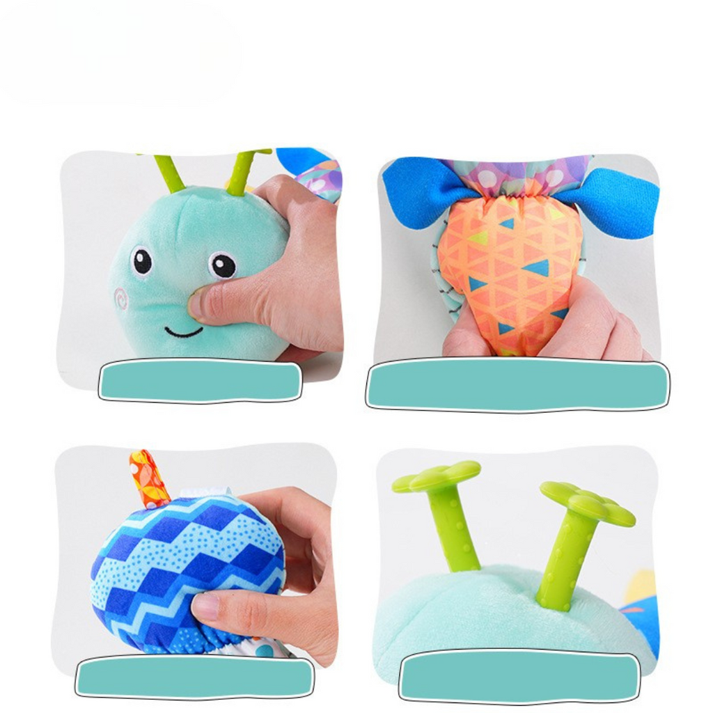 Neonato che gioca con il Bruco Musicale in peluche, esplorando le diverse texture e ascoltando le melodie