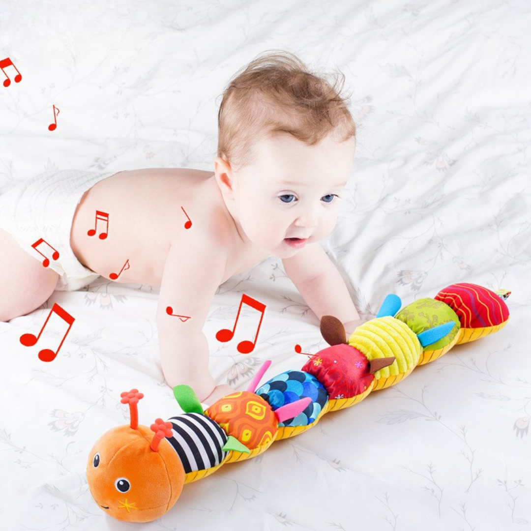 Bambino che afferra il Bruco Interattivo Musicale, sviluppando coordinazione occhio-mano e abilità motorie